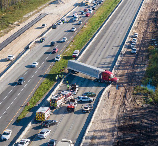 Jackknifed tractor trailer blocking highway lanes