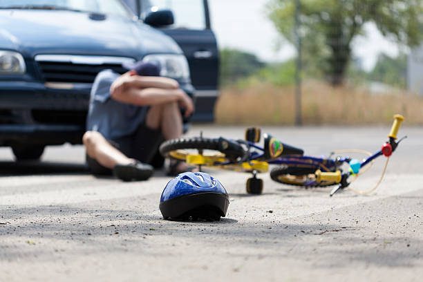 Blue helmet near fallen bicycle and car