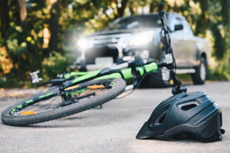 Fallen bicycle and helmet near pickup truck