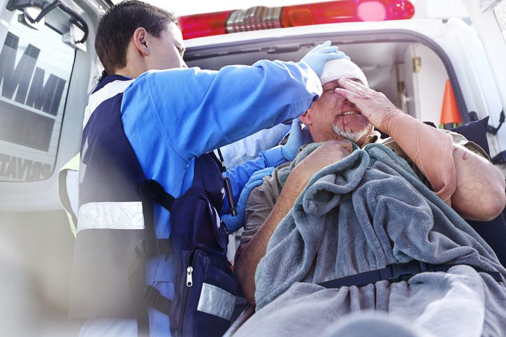 Paramedic dressing head wound of male patient